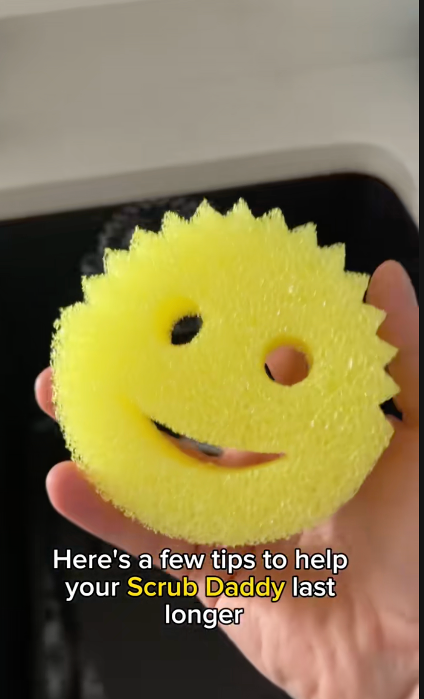 Hand holds a yellow, smiling Scrub Daddy sponge above a sink. Text reads: “Here's a few tips to help your Scrub Daddy last longer.”